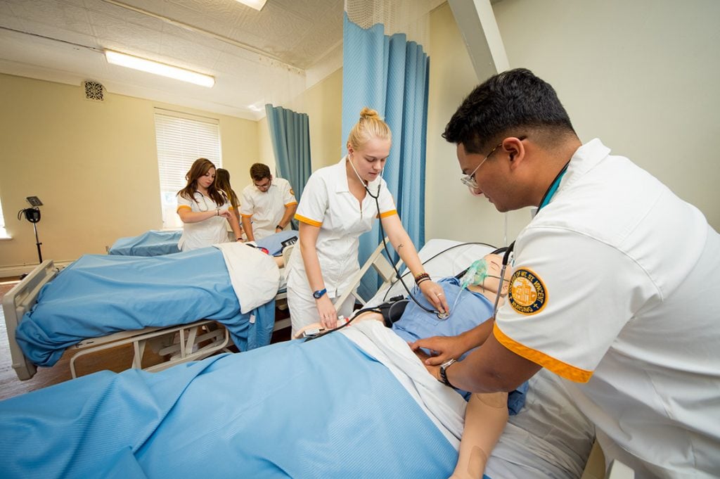 Nursing students practicing on manikin