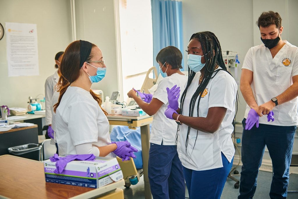 Nursing students having a conversation in a clinical setting