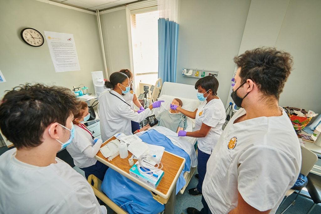 Nursing students practicing on a manikin