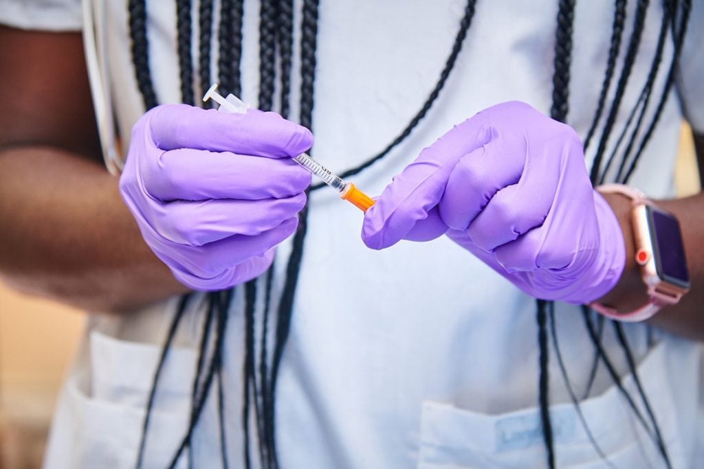 Close up of nurse hands in purple gloves