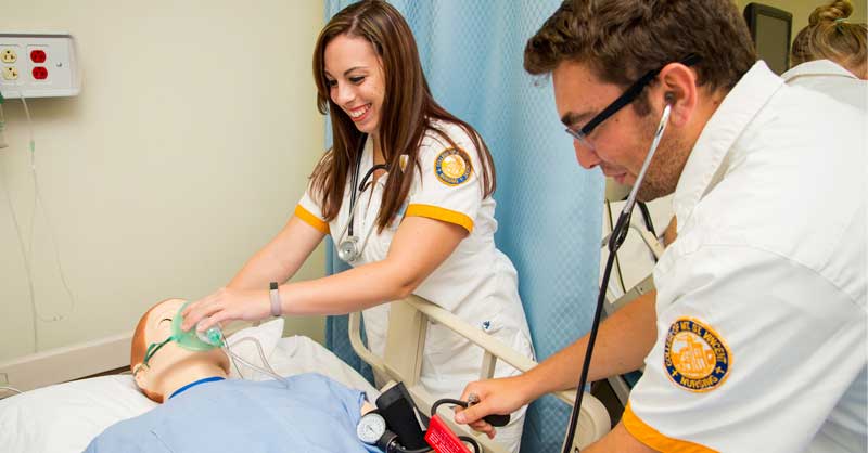 two ABSN students working in sim lab