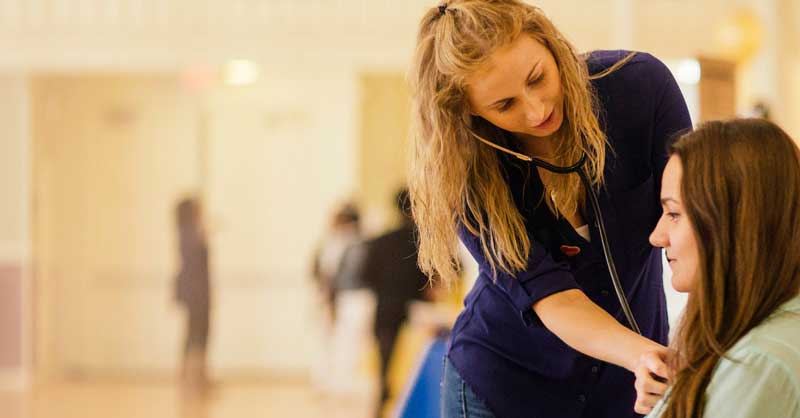 nursing student checking patient's heartbeat