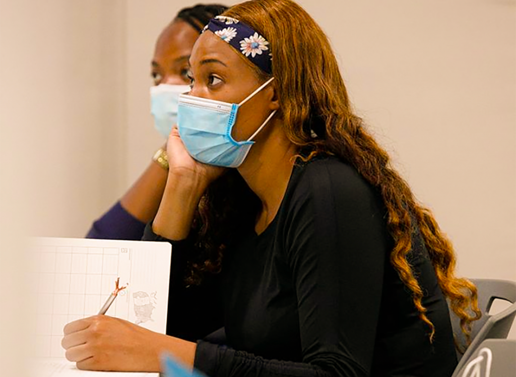 two nurses listen to lecture