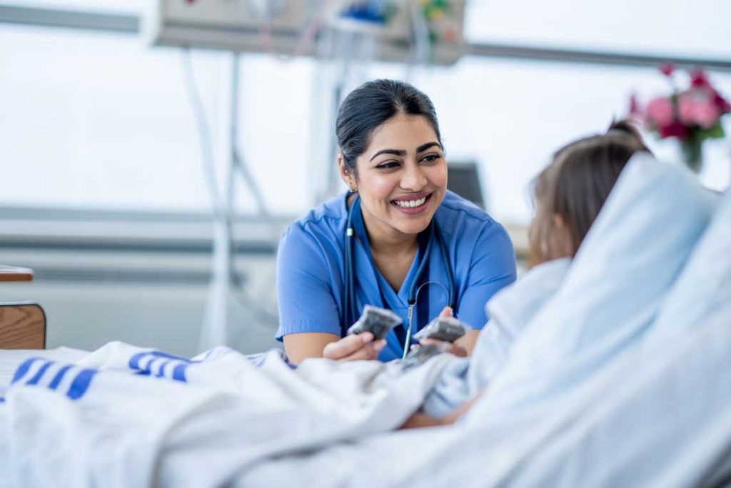 nurse with patient in hospital bed