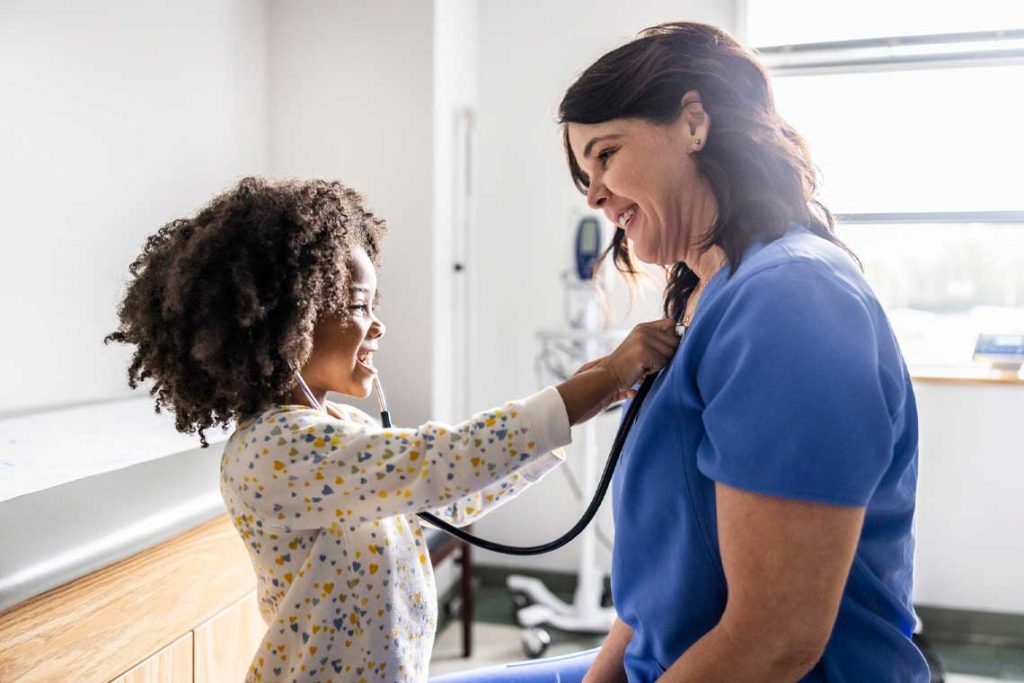 nurse smiling and talking to child patient