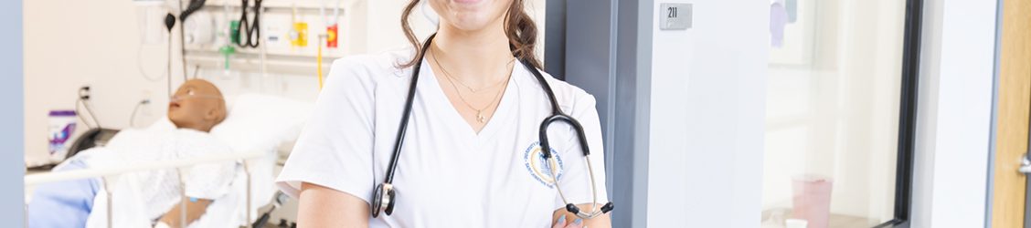 Nursing student leaning in doorway of sim lab