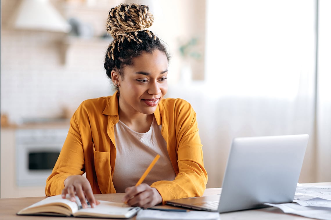 Woman with laptop taking notes