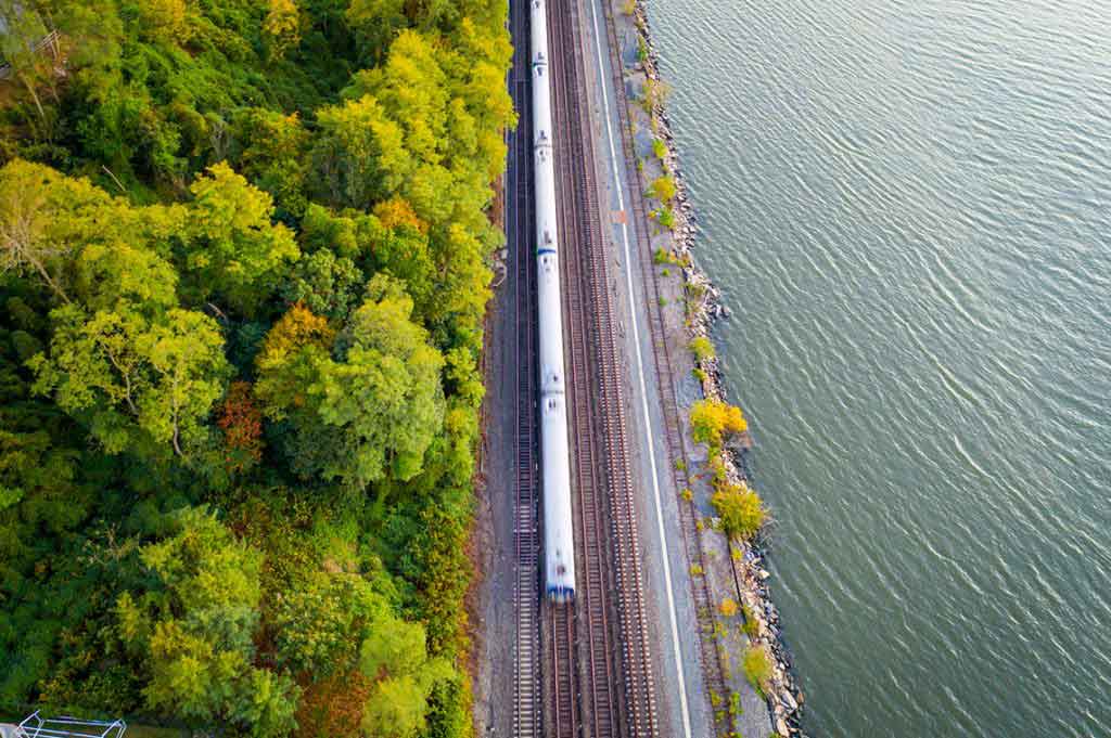 train moving on train tracks next to body of water