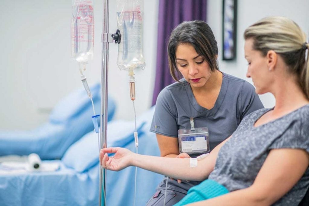 nurse helping patient with IV