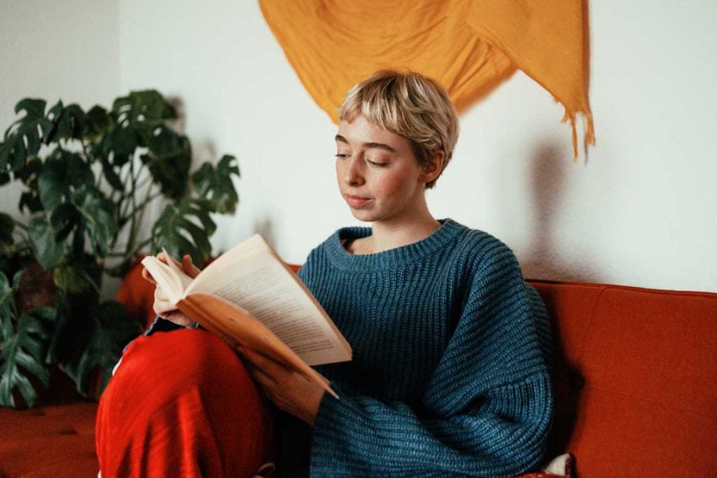 A nursing student reading on a couch