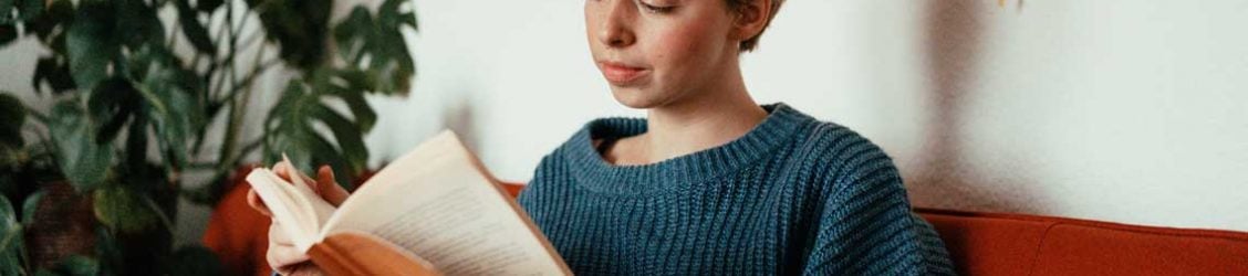 A nursing student reading on a couch