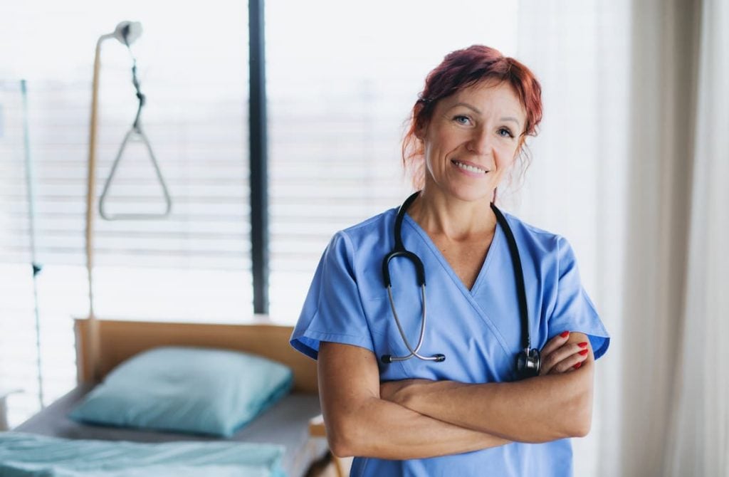 Nurse standing by a bed
