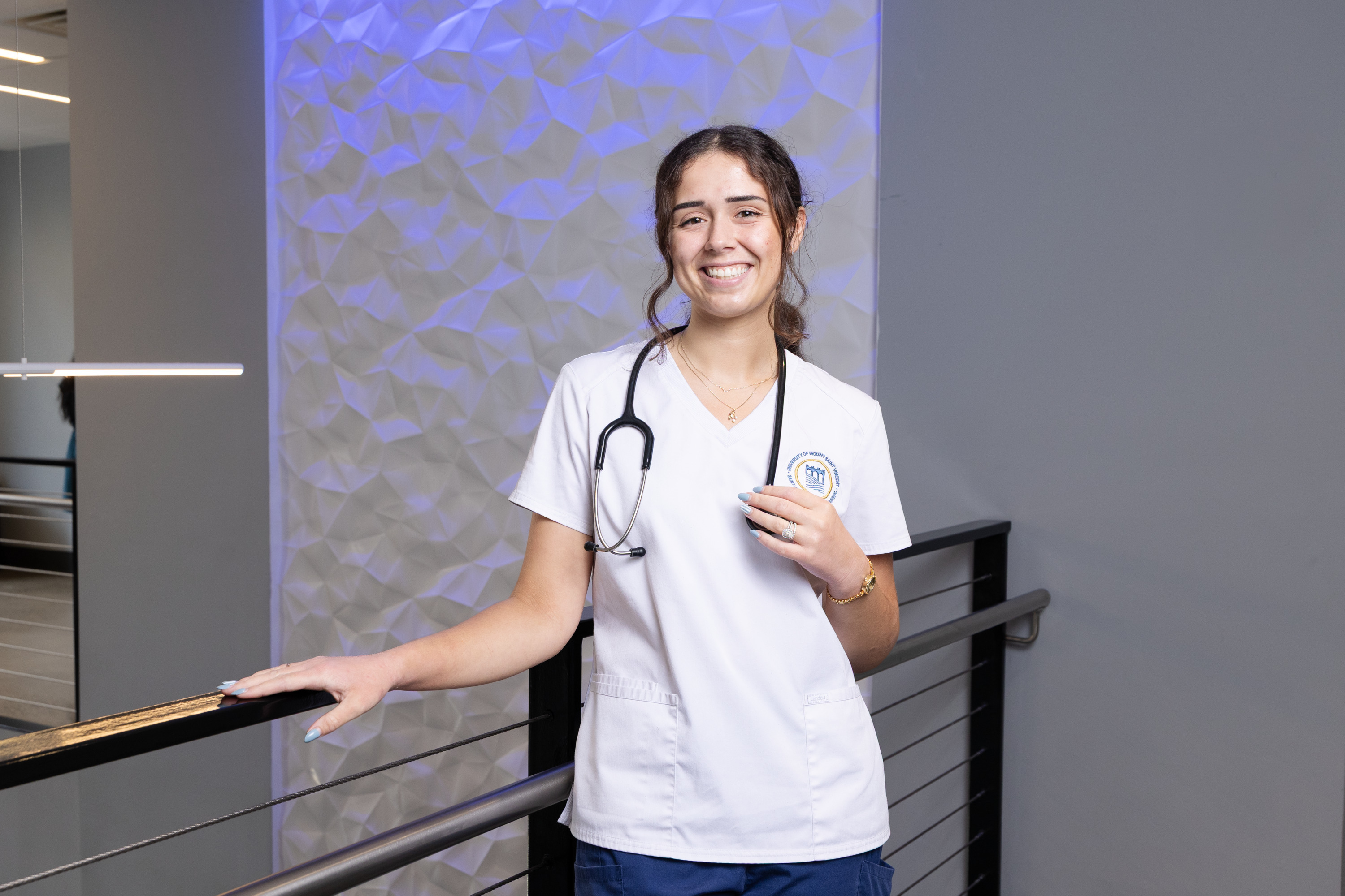 Nursing student standing by railing